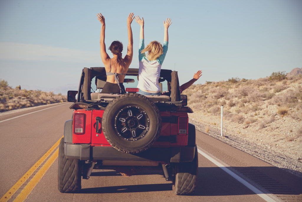 a jeep driving with two girls sitting in the backseat discussing student loan refinance misconceptions