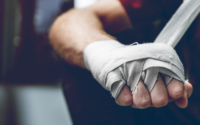 Millennial wrapping a bandage on his hand