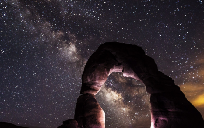 Image of stone arch at night, milky way in night sky