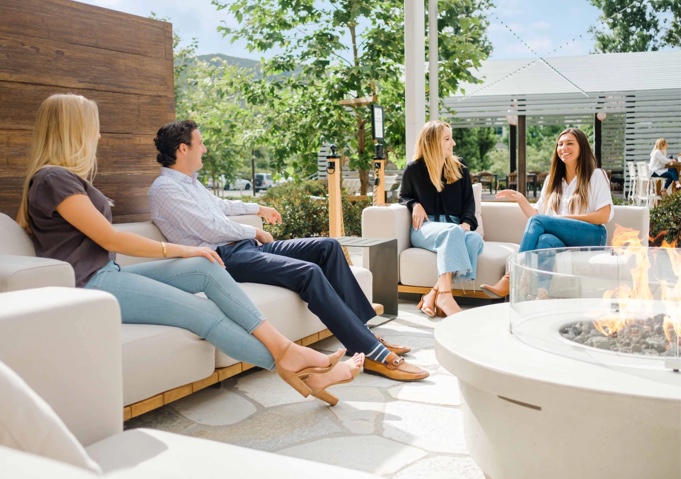 Four friends sitting on a patio, having a conversation.