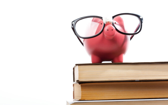 piggy bank on a stack of books, wearing glasses