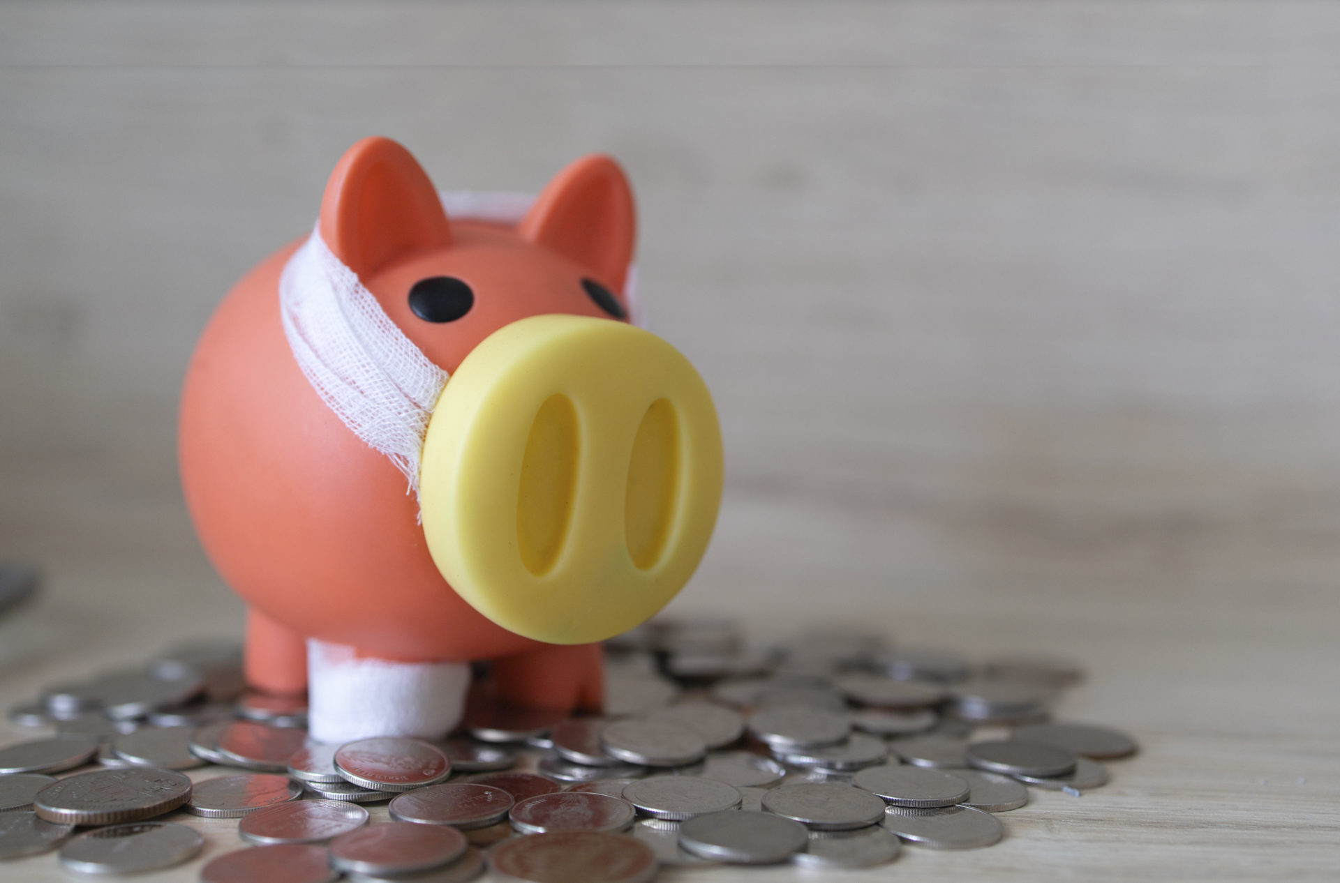Red color piggy bank on top of coins showing the importance of saving money and financial planning