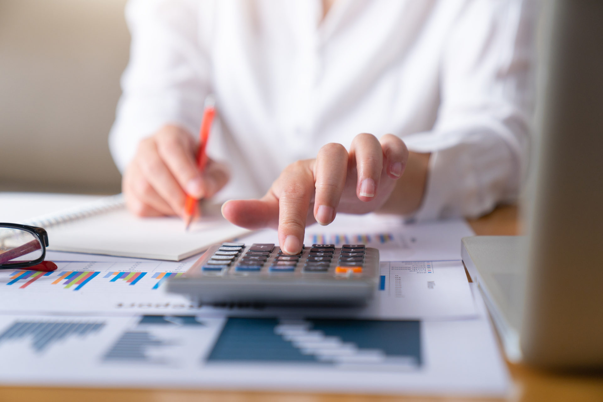 Woman with notes and calculator calculating the payoff of student loans.