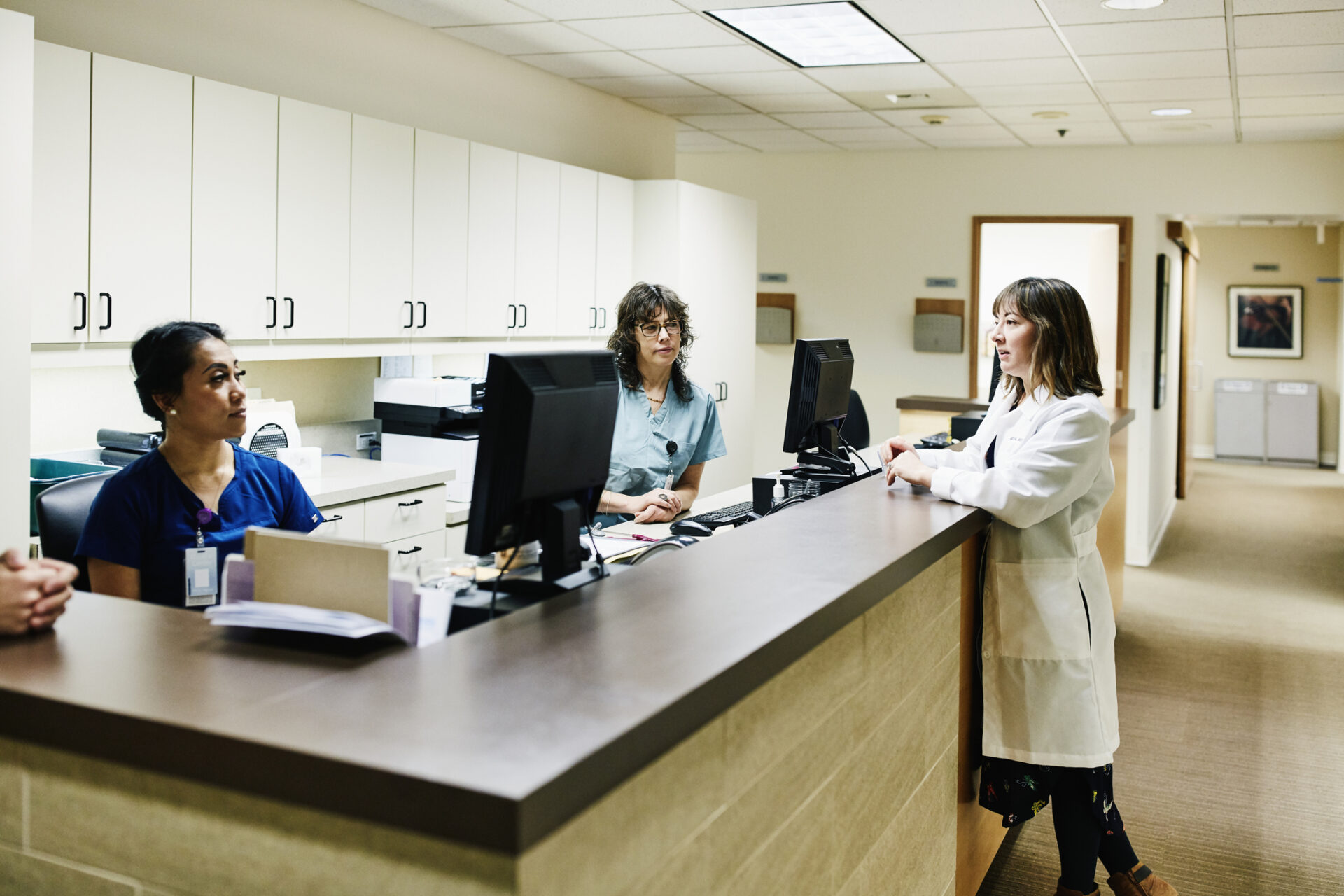 Doctors and nurses in discussion at nurses station in hospital