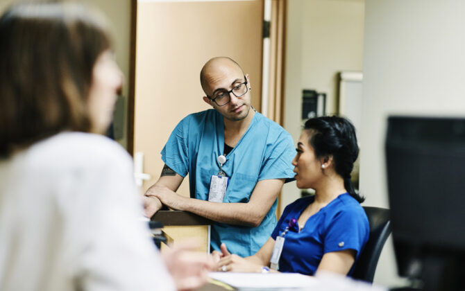 Medical staff in discussion at nurses station in hospital