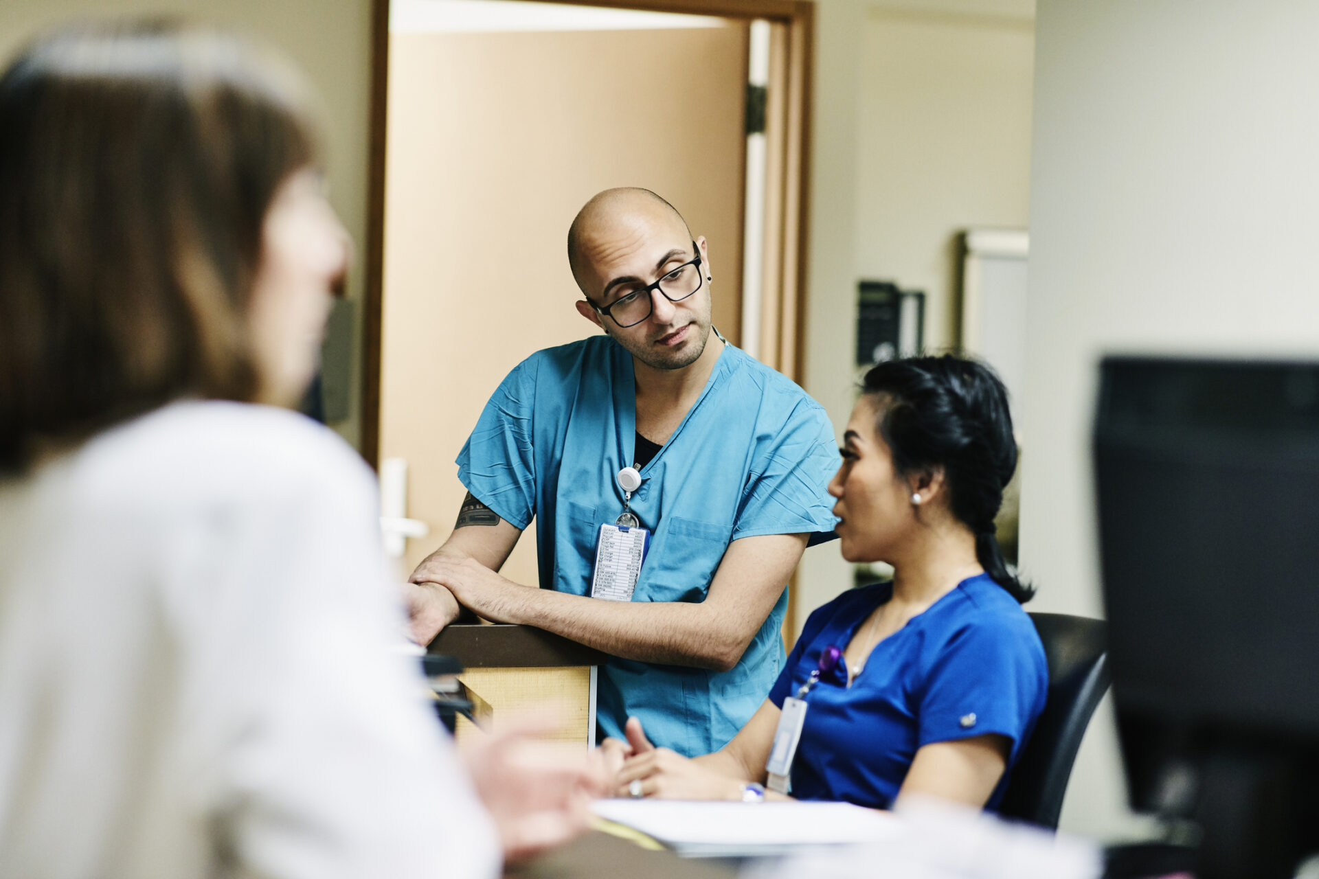 Medical staff in discussion at nurses station in hospital