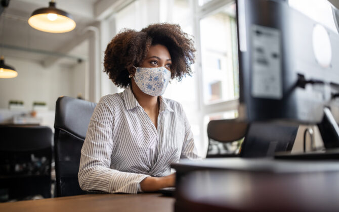 Businesswoman with face mask working at her desk