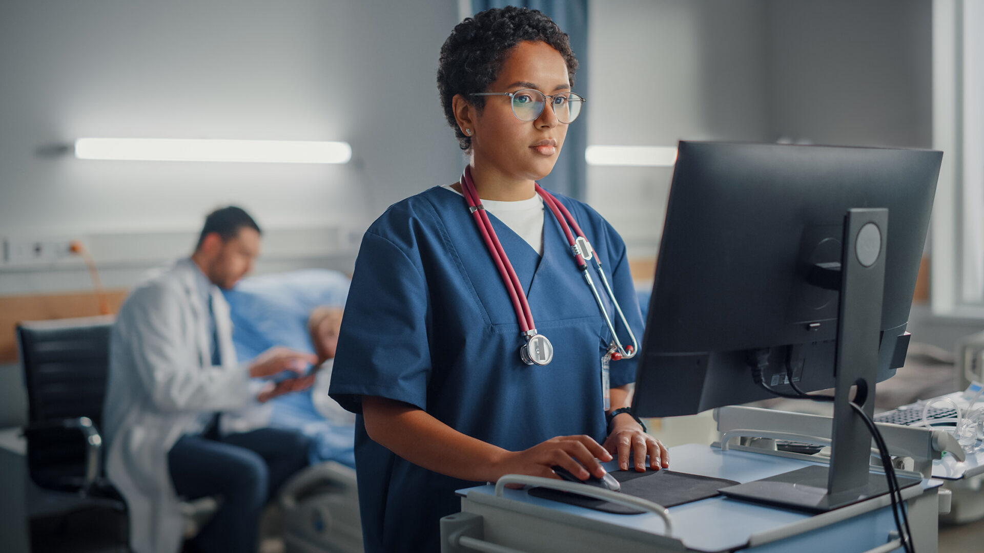 Hospital Ward: Professional Smiling Black Female\Doctor Wearing Stethoscope Using Computer.