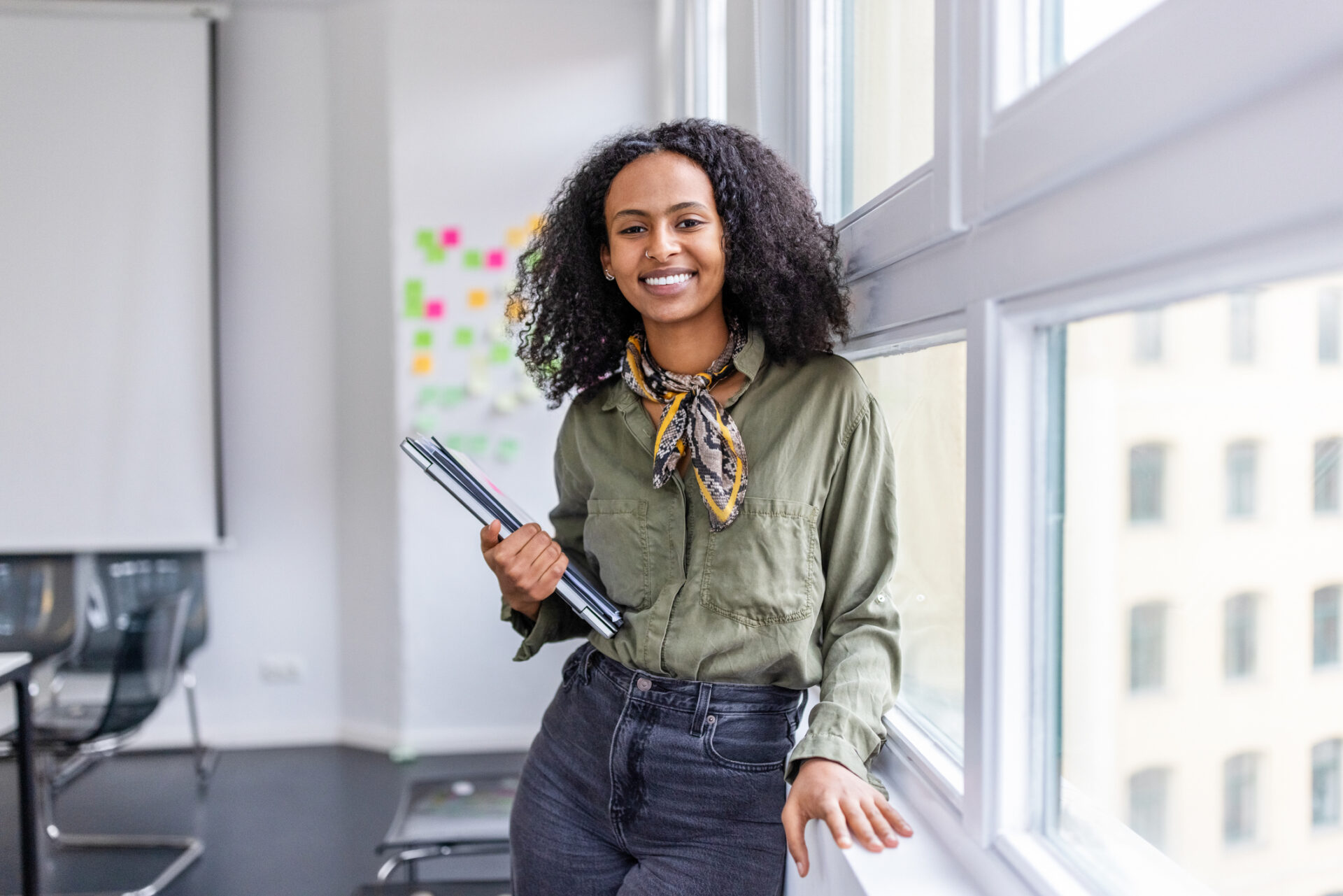 Girl standing and smiling near a window after Applying for a Checking Account with Direct Deposit Bonuses