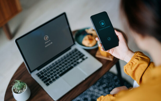 A woman using security software on her phone to protect herself from common scams