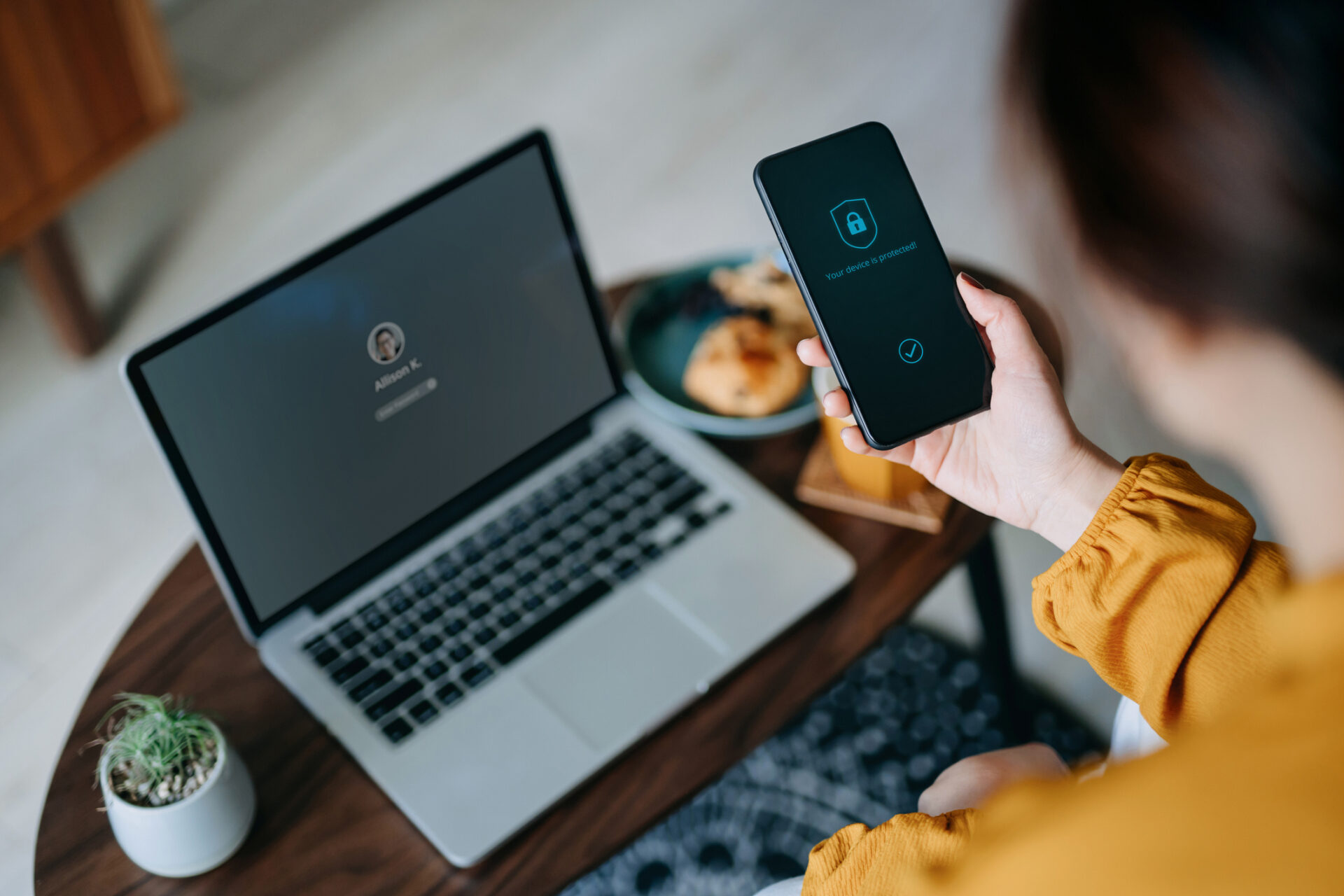 A woman using security software on her phone to protect herself from common scams