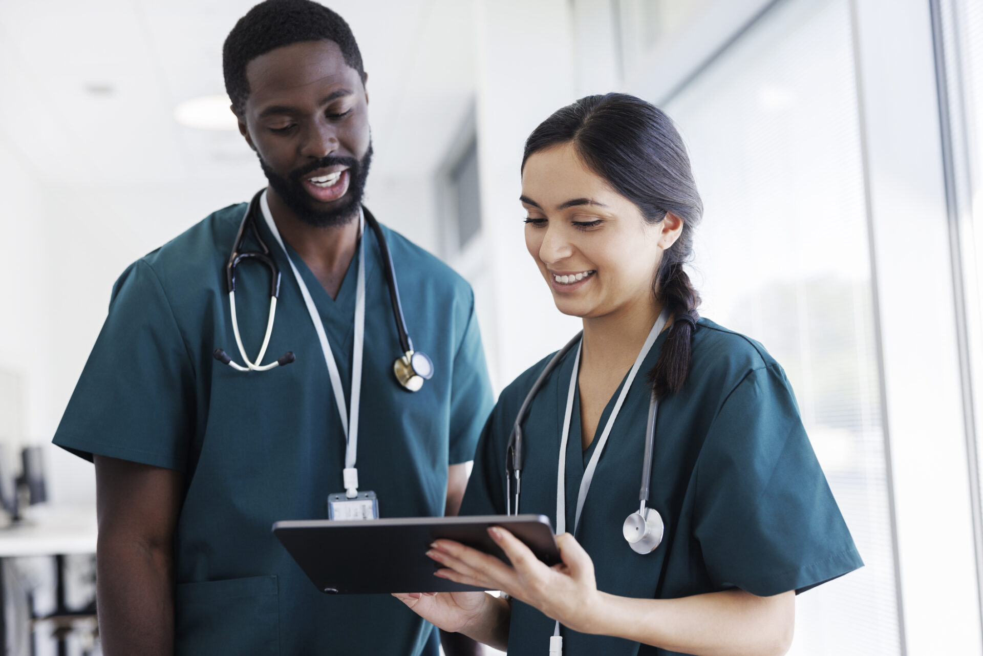 A male and a female doctor are comparing PSLF programs for nonprofit hospitals and private sectors