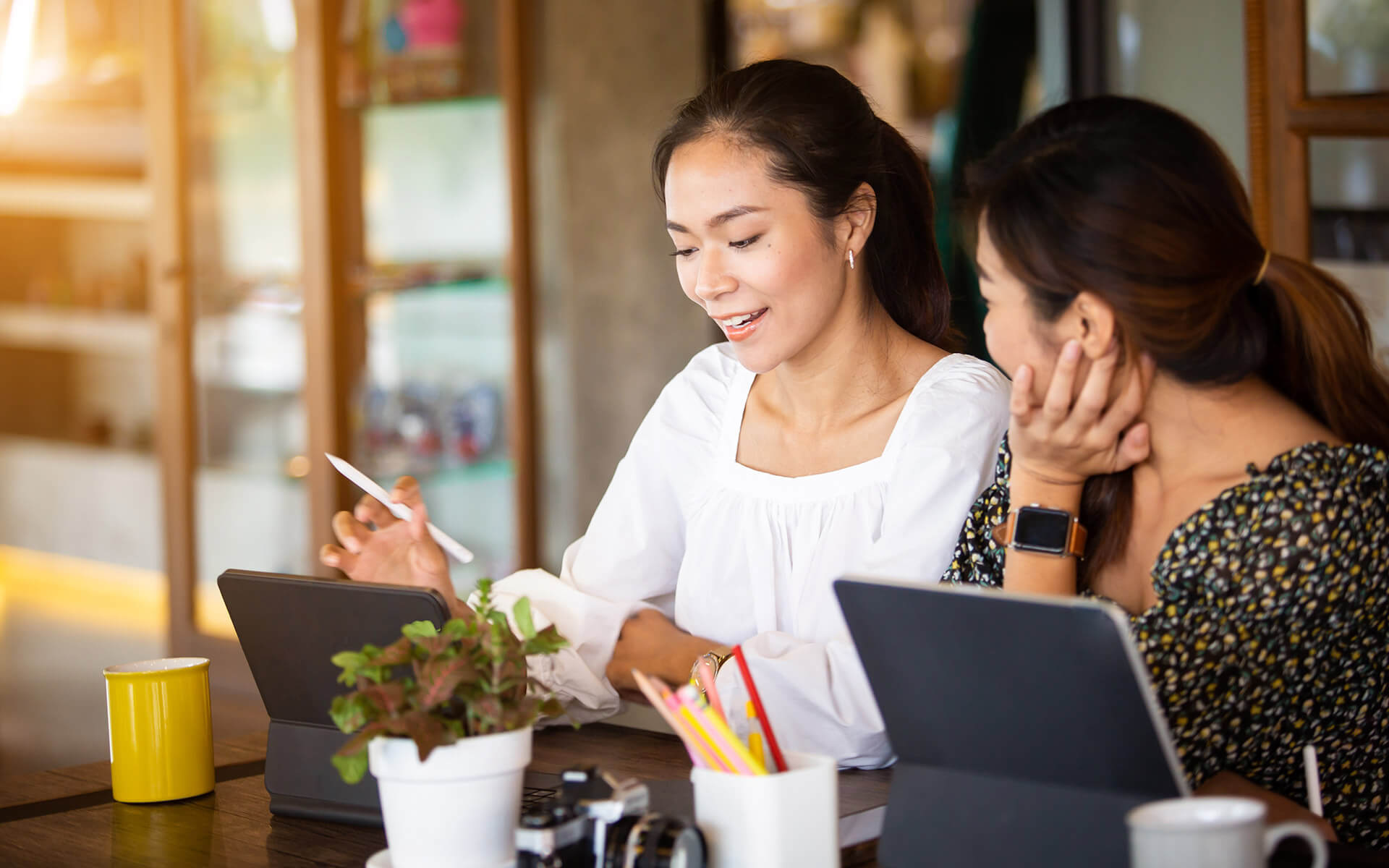 Two women checking if their refinanced student loans are eligible for forgiveness.