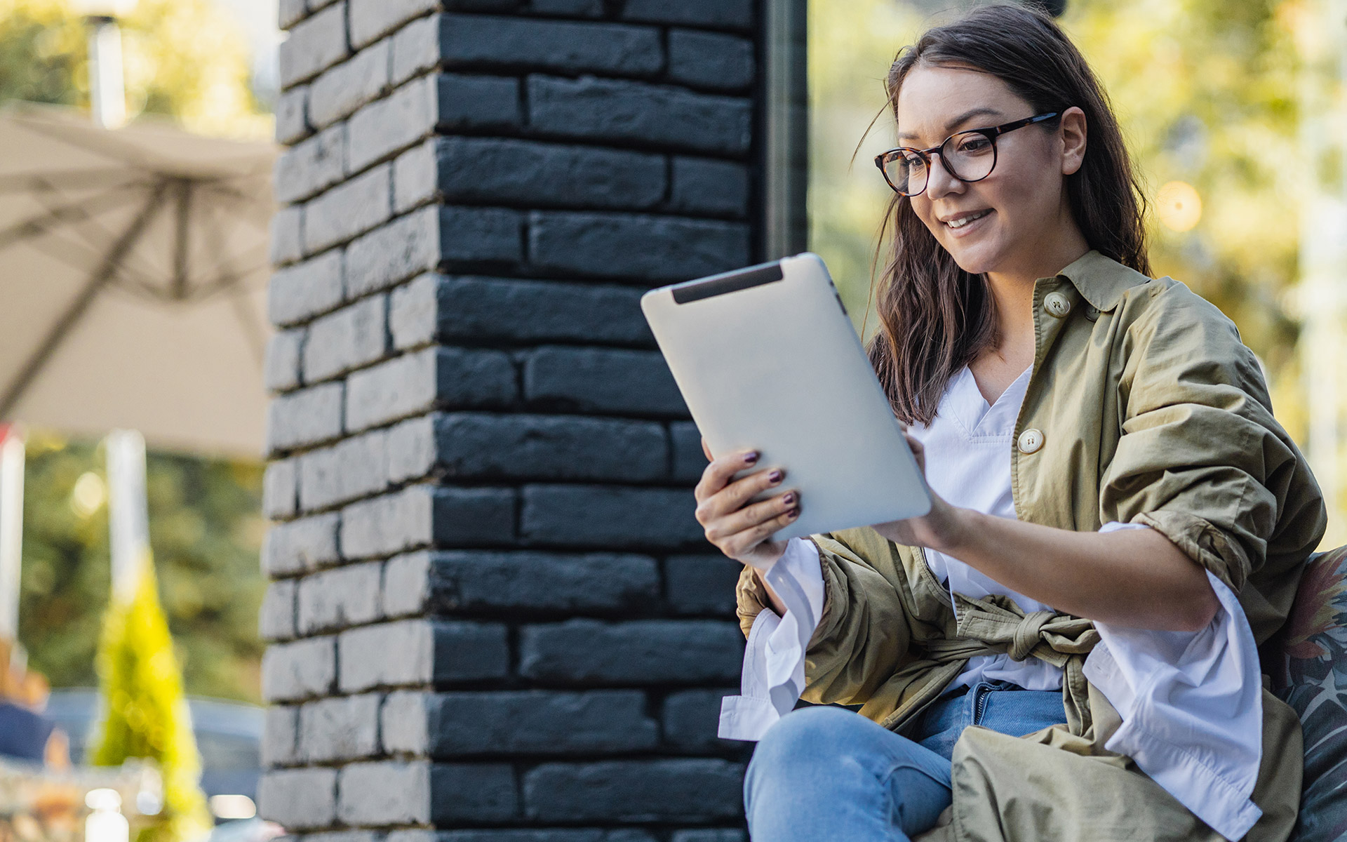 Woman outside reading tablet learning about student loan forgiveness through income-driven repayment